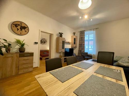 a dining room table with chairs and a living room at Bobbys Gartenapartment in Krems an der Donau