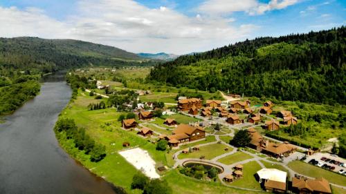 una vista aerea di un villaggio vicino a un fiume di TAOR Karpaty Resort & Spa a Skhidnytsia