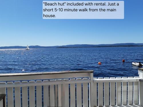 a picture of a large body of water with a white fence at Flaskebekk at Nesodden with unbeatable Oslo Fjord views and a private beach hut in Nesoddtangen