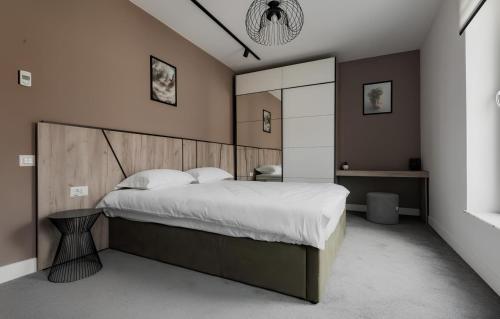 a bedroom with a large bed with a wooden headboard at GAVAS Modern Central Apartments in Cluj-Napoca