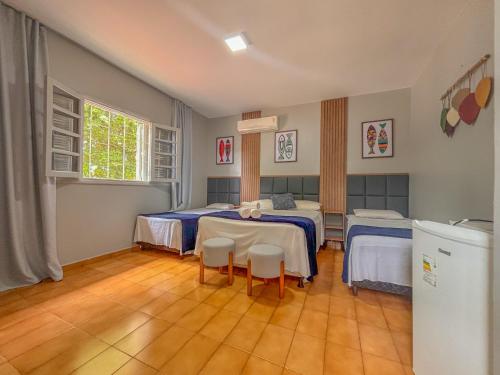 a room with two beds and a table and chairs at Pousada de Bonito in Bonito