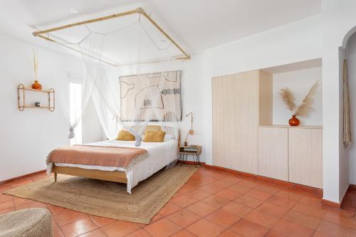 a bedroom with a bed with a canopy at Quinta Flamingos - Live, Work, Play in Corroios