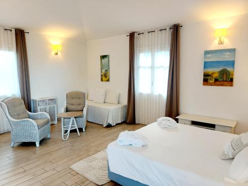 a hotel room with two beds and a chair at Hotel La Villa Del Mare in Cagliari