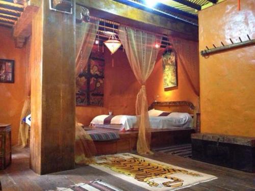 a bedroom with two beds with curtains and a rug at House Of Shambhala in Lhasa