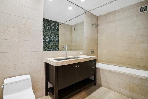 ein Badezimmer mit einem Waschbecken, einem WC und einer Badewanne in der Unterkunft FURNISHED Oversized 1 Bedroom with Home Office (Short-Term Available) in New York