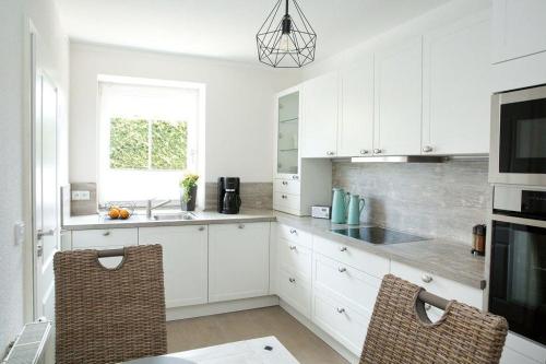 a kitchen with white cabinets and a sink at Storchenblick-No-1 in Winsen