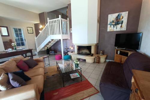 a living room with a couch and a fireplace at La maison de Béa in Le Rouget