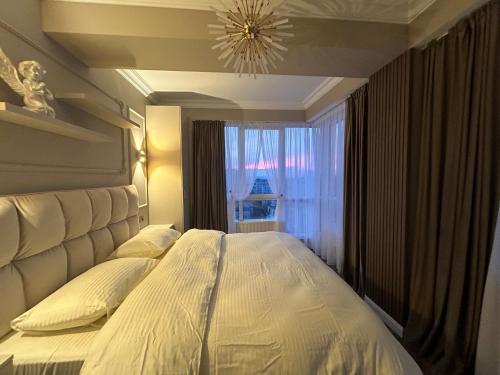 a bedroom with a large bed with a window at GT apartments in Chisinau in Chişinău