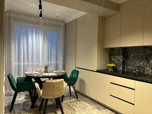 a dining room with a table and chairs and a kitchen at GT apartments in Chisinau in Chişinău