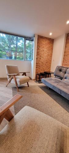 1 dormitorio con cama, sofá y mesa en Apartaestudios Margarita, en Bogotá