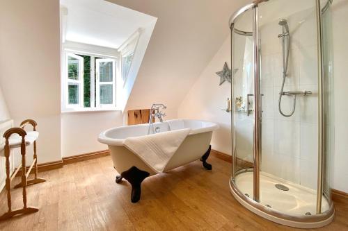 a bathroom with a bath tub and a shower at Althea House with parking in Padstow