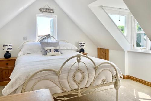 um quarto com uma cama branca num sótão em Althea House with parking em Padstow