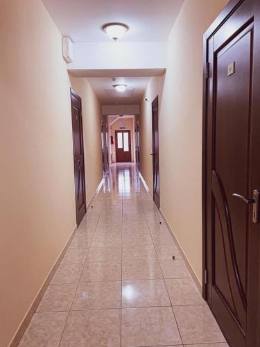 a hallway with doors and a tile floor in a building at Hincesti Hotel in Hînceşti