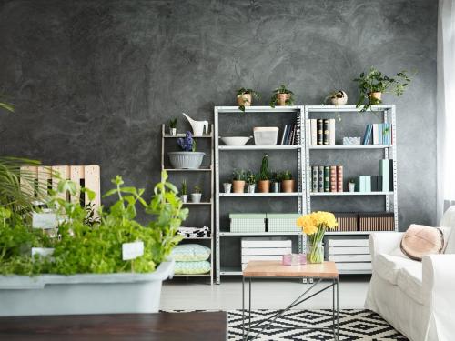 una sala de estar con una estantería blanca llena de plantas en modern House, en Chennai
