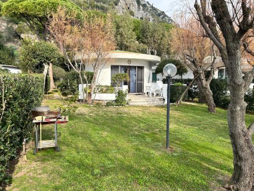 ein weißes Haus mit einem Tisch und einer Lampe im Gras in der Unterkunft Fronte Mare Villa Acquasanta zona "LA FIUMETTA" Terracina in Terracina