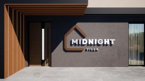 un edificio con un cartello di mezzanotte sul lato. di Midnight Villa a Cerkvenjak