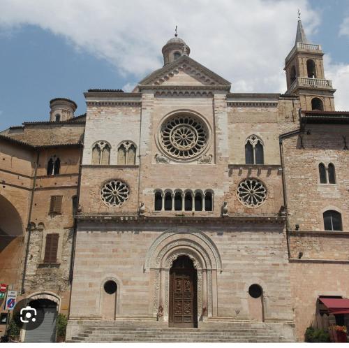 a large brick building with a clock tower at Affitta camere Via Piave in Foligno