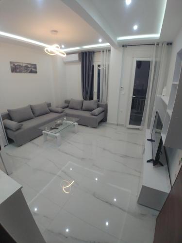een woonkamer met een bank en een tafel bij Λαμπερό Διαμέρισμα 1 in Thessaloniki
