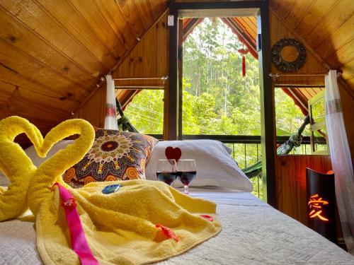 um quarto com uma cama com dois cisnes em Alto na Montanha Chalé 1 em Viscode de Mauá