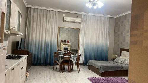 una cucina e una sala da pranzo con un tavolo e un letto di Rasul Rza a Baku