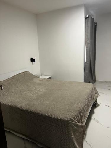 a bedroom with a bed with a brown blanket at Luqa 3 bedroom penthouse T in Luqa