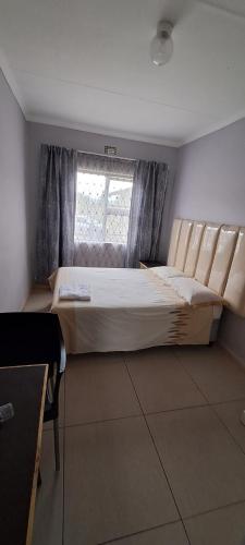 a large bed in a room with a window at Matat Studio Apartments in Matatiele
