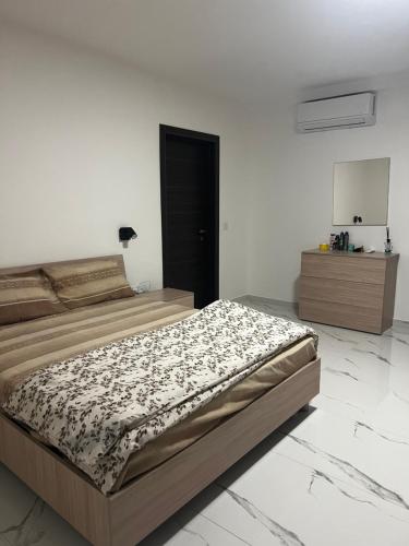 a bedroom with a large bed and a dresser at Luqa 3 bedroom penthouse T in Luqa