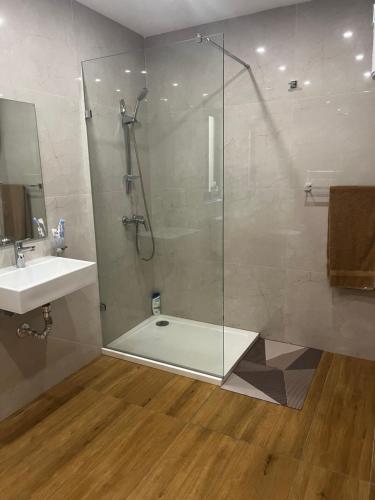y baño con ducha y lavamanos. en Luqa 3 bedroom penthouse T en Luqa