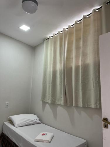 Zimmer mit 2 Betten und einem Vorhang in der Unterkunft Hostel São João in Araçariguama