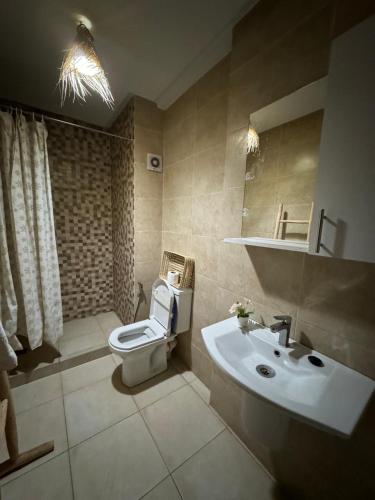 a bathroom with a white toilet and a sink at Cosy & magnifique appartement Marrakech in Marrakech