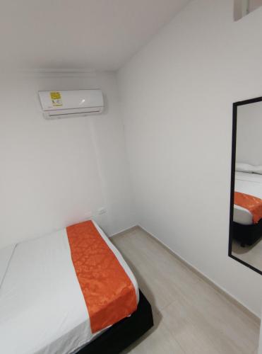 a white room with a bed and a mirror at Cabaña Gaia Rodadero in Santa Marta