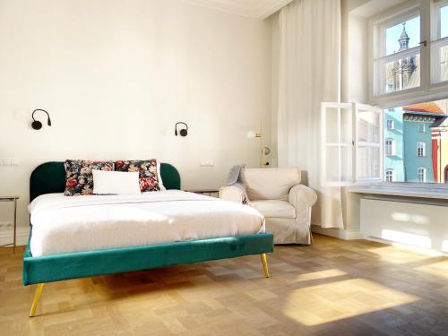 1 dormitorio con 1 cama y 1 silla en Mint Luxury Apartments at the Main Square en Cracovia