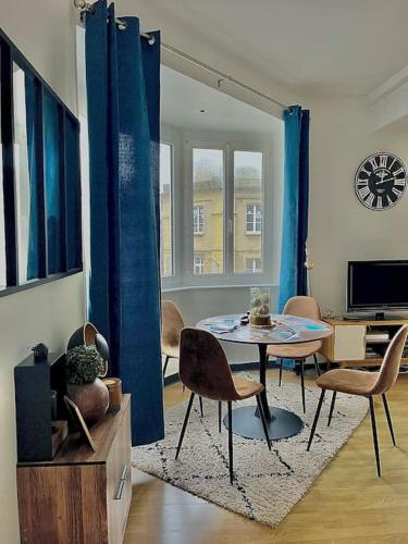 un salon avec une table et des chaises dans l'établissement Le Cocon Briochin, grand appartement en plein centre de SaintBrieuc, à Saint-Brieuc