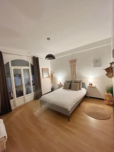 - une chambre blanche avec un lit dans l'établissement Le Cocon Briochin, grand appartement en plein centre de SaintBrieuc, à Saint-Brieuc