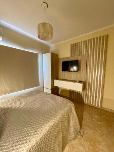 a bedroom with a bed and a flat screen tv at Chill Home IV in Posadas