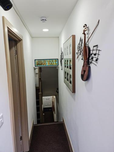 a hallway with a violin hanging on a wall at SureBillionaire Homes II in London