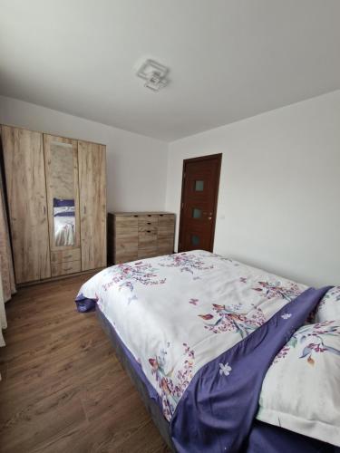 a bedroom with a bed and wooden floors at Downtown Apartment in Râmnicu Vâlcea