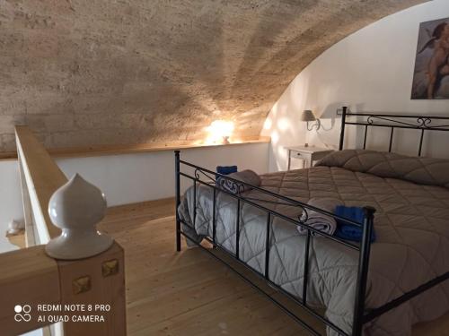 ein Schlafzimmer mit einem Bett in einem Zimmer in der Unterkunft Porta Sant'Antonio in Grottaglie
