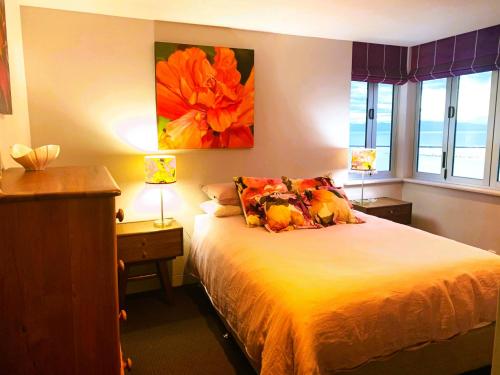 納爾遜的住宿－Stunning Views over Tasman Bay，一间卧室配有一张带两盏灯的床和两扇窗户。