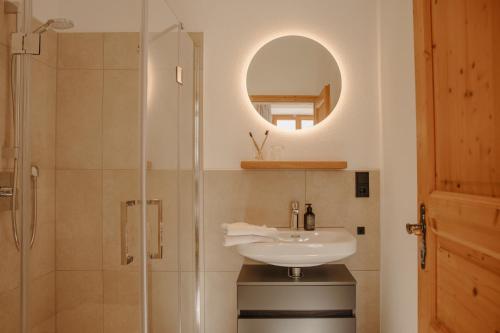 a bathroom with a sink and a shower with a mirror at Staudingerhof in Staudach-Egerndach