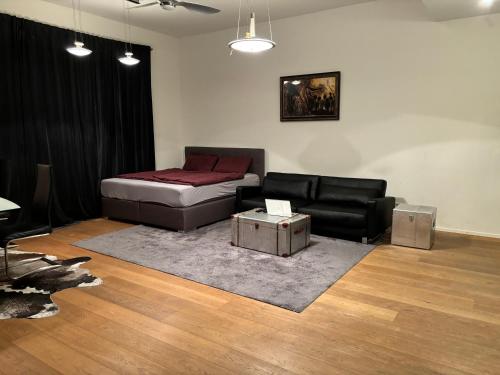 een woonkamer met een bank en een bed bij Luxusapartment Hamburg Hafencity in Hamburg