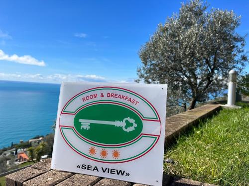 a sign that reads room and breakfast next to the water at Sea View in Pieve Ligure