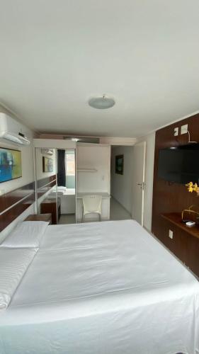 een slaapkamer met een groot wit bed in een boot bij Flat Manaíra Palace Beira Mar in João Pessoa