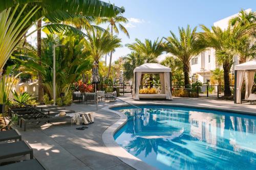 a swimming pool with a gazebo and palm trees at Sonder The Deco in Miami Beach