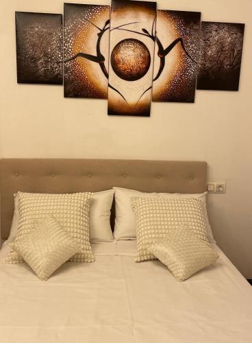 a room with a bed with four paintings on it at Alojamiento Alameda in Redondela