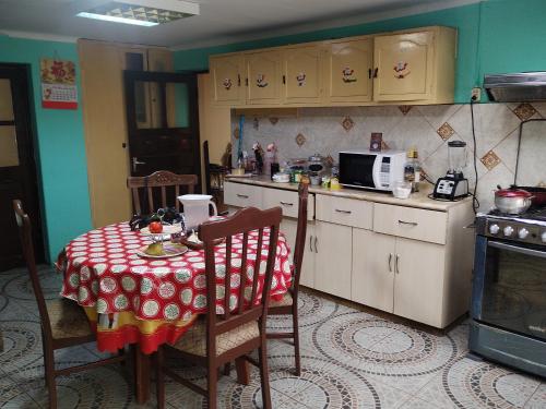 a kitchen with a table with a red and white table cloth at Casa Sánchez in Huancayo