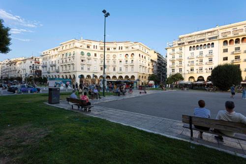 a group of people sitting on benches in front of a building at Couple-in magical suite with jacuzzi in Thessaloniki