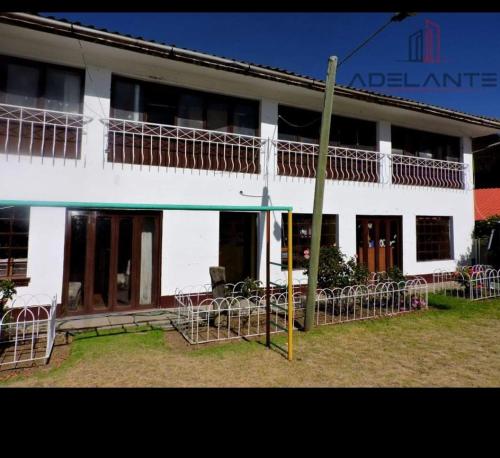 un bâtiment blanc avec des tables et des chaises devant lui dans l'établissement Casa Sánchez, à Huancayo