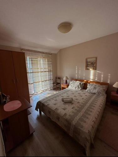 Un dormitorio con una cama grande y una ventana en Modern and homely family house., en Cetinje