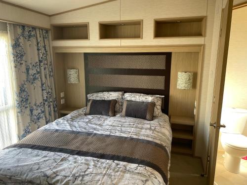 a bedroom with a large bed with a wooden headboard at Golden Sands, Ingoldmells, 6 berth in Ingoldmells